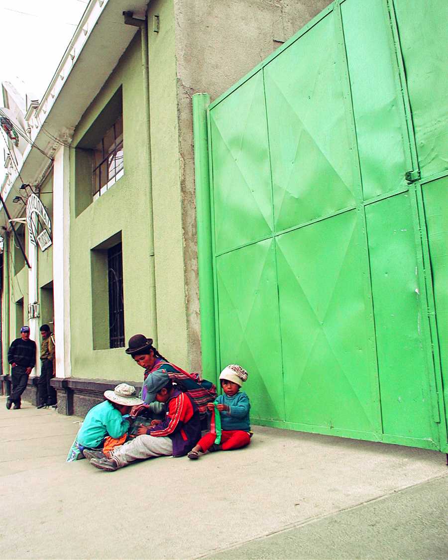 Family beside a green door in Oruro