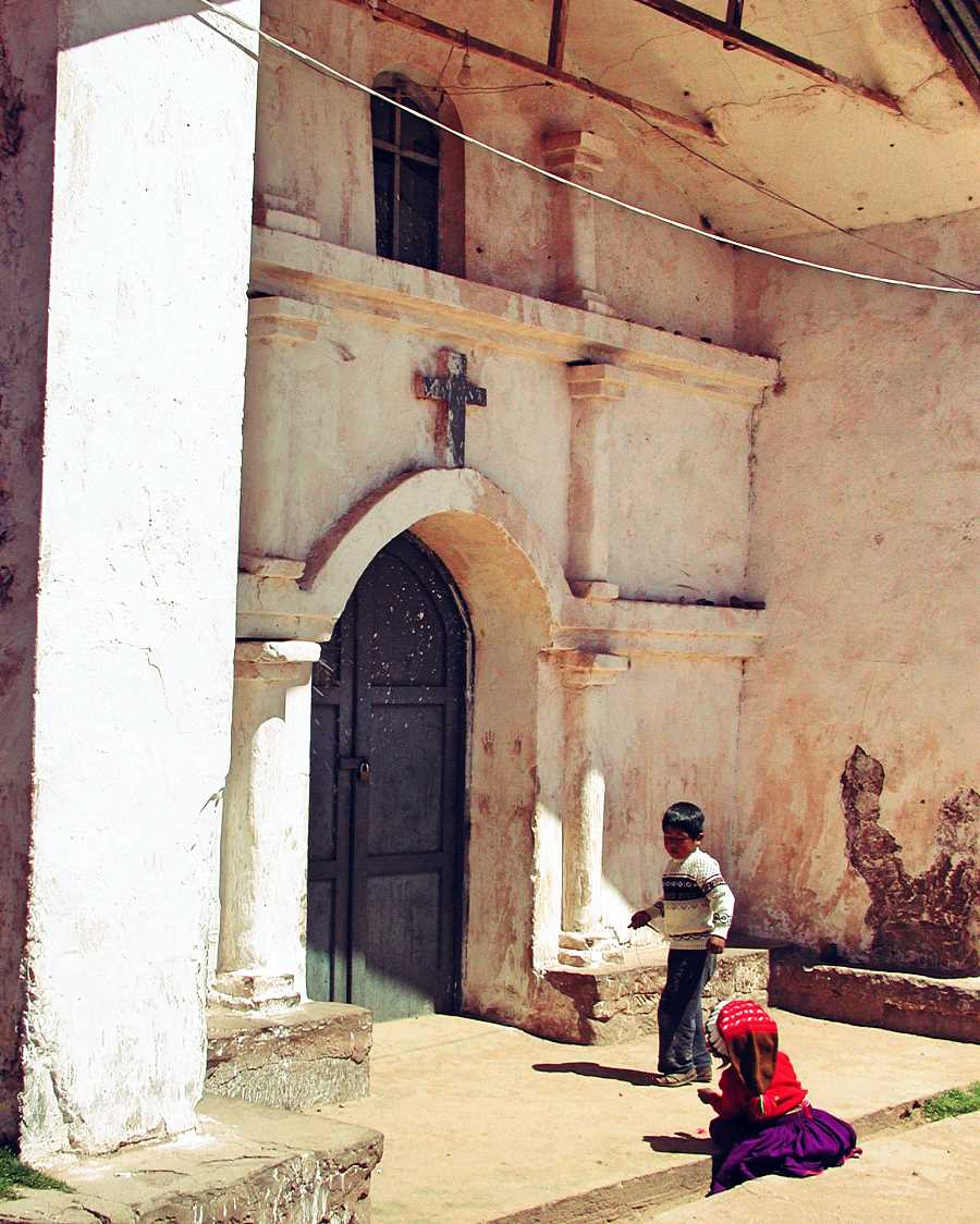 Children playing outside a church. Lake Titicaca, Peru