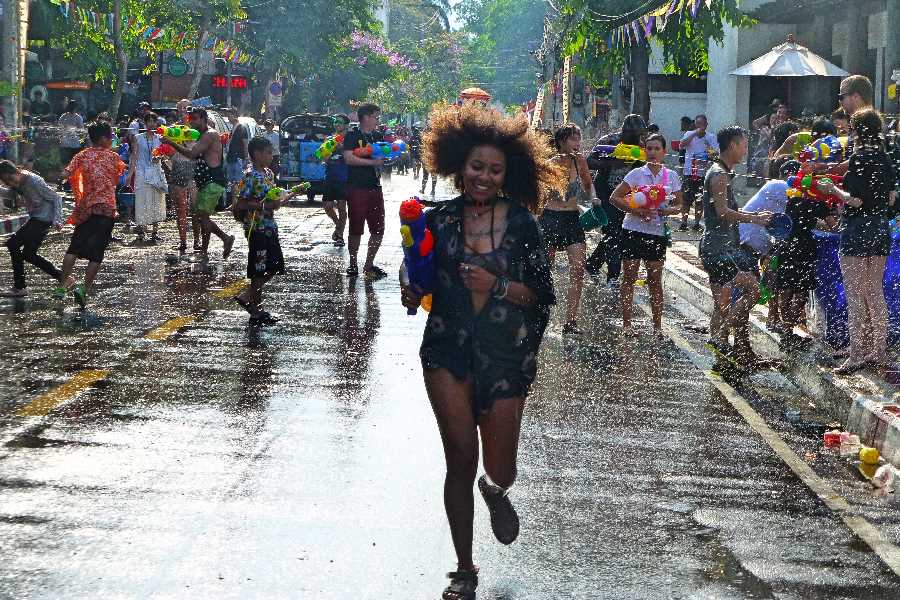 A woman runs past a water fight