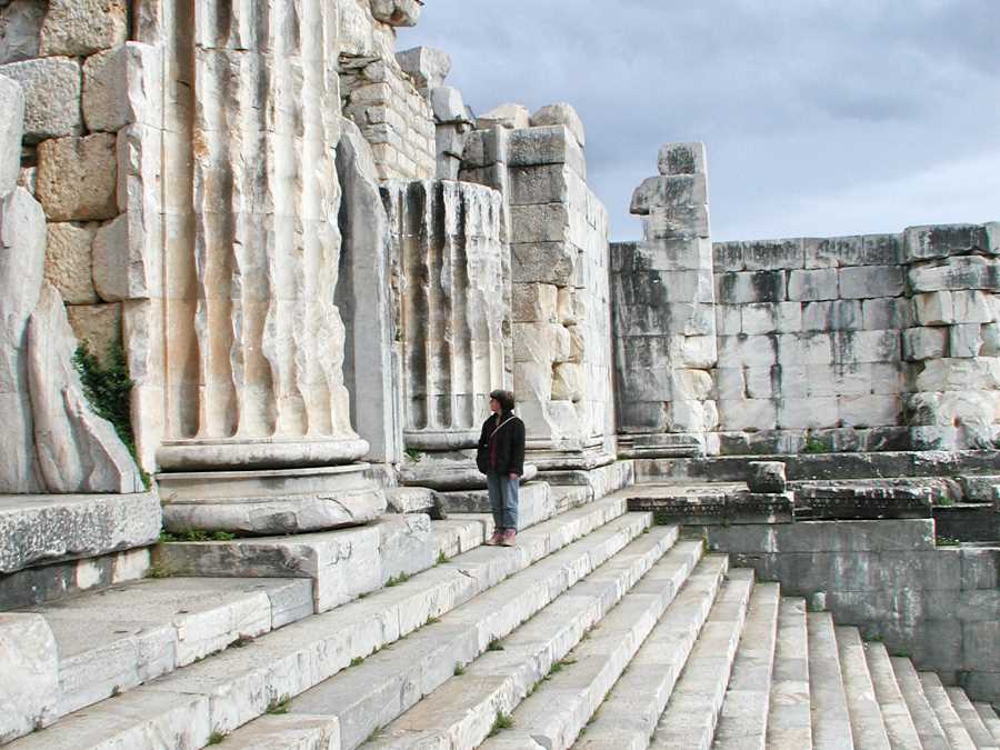 Woman stands on steps leading into the Apollo Temple