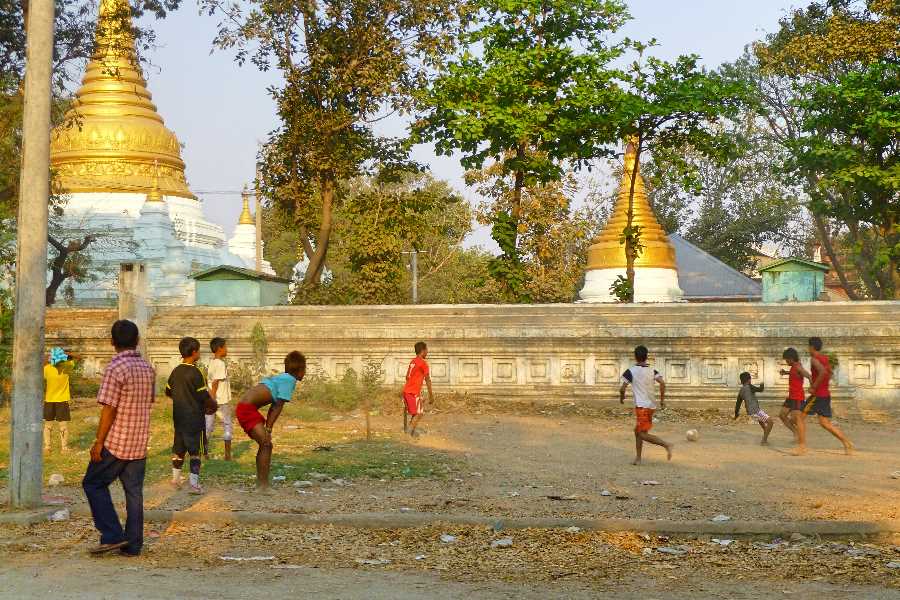 Pagodas provide the backdrop to a casual game beside a Buddhist temple